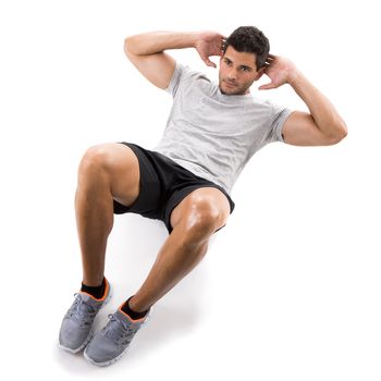 Athletic man running doing abdominals, isolated over a white background