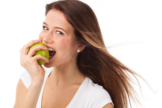 Young woman biting a green apple, isolated on white