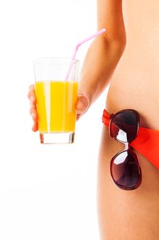Part of a female body wearing a bikini, sunglasses and orange juice, isolated on white