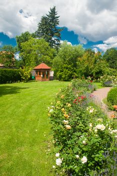 Beautiful garden with blooming roses and a small gazebo