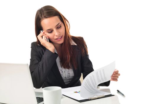 Young business woman on the phone, working in front a laptop, isolated on white 