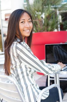 Happy asian girl working on her laptop, businesswoman or student