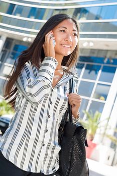 Pretty asian girl walking and talking on cell phone