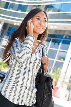 Pretty asian girl walking and talking on cell phone