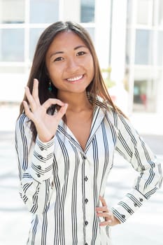 Portrait of a pretty asian woman with positive gesturing
