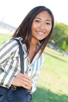 Cheerful asian girl walking in a park
