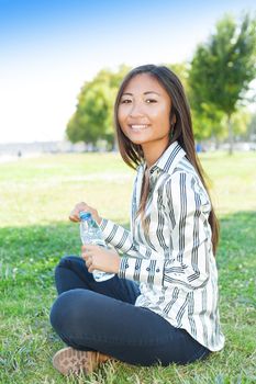 Portrait of an beautiful asian girl in a park with a bottle of water