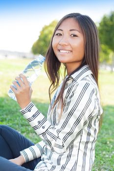 Portrait of an young asian girl in a park with a bottle of water