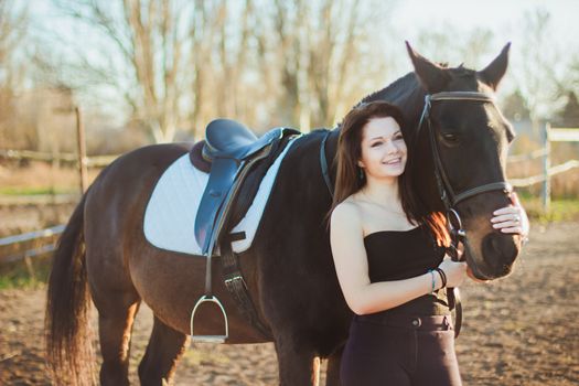 Young woman with a horse on nature