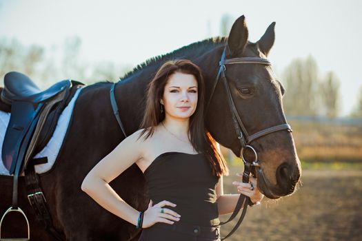 Young woman with a horse on nature