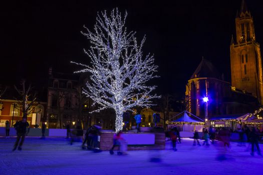 Ice-skating people at the night in Christmas ice-rink, Maastricht, the Netherlands