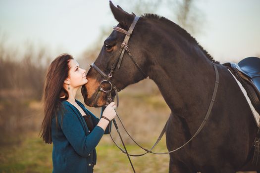 Young woman with a horse on nature