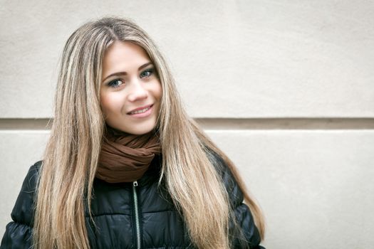 Portrait of a young woman and wall in background