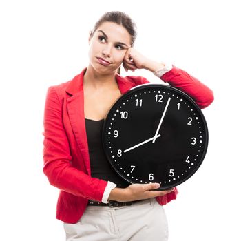 Bored business woman holding a big clock on the hands