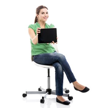 Beautiful female student sitting on a chair showing something on a tablet, isolated over a white background