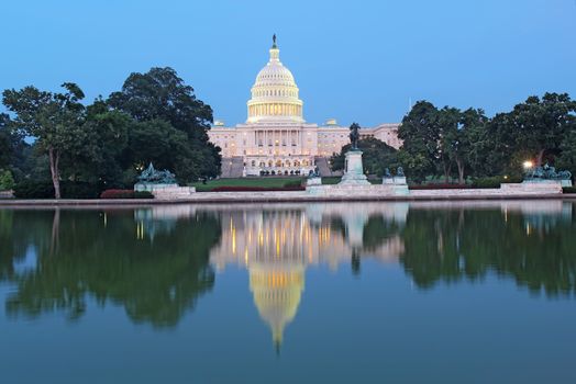 The west side of the United States Capitol building and Ulysses S Grant memorial in Washington, DC reflected in the reflecting pool just after sunset