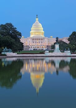 The west side of the United States Capitol building and Ulysses S Grant memorial in Washington, DC reflected in the reflecting pool just after sunset vertical