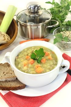 a white cup with pea soup and parsley