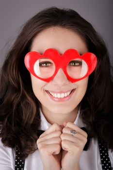 Portrait of a beautiful girl wearing heart-shaped glasses.