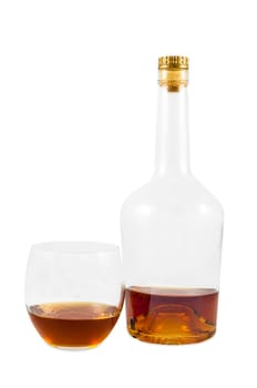 Almost empty bottle and glass of whiskey isolated on white background with clipping path