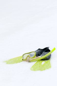 Mask and flippers lying on the snow, conceptual photo