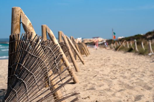 Shot of fence on the beach, blue sky and sand