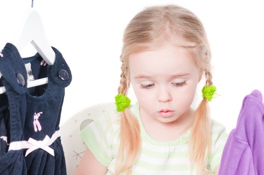 Shot of cute toddler girl choosing clothes