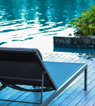 Closeup chaise longue with swimming pool background