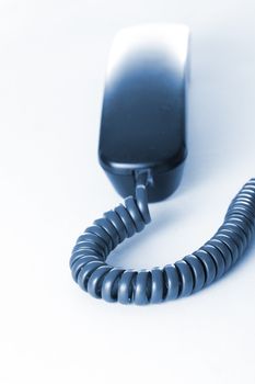 A telephone receiver in cold blue tones. Business concept