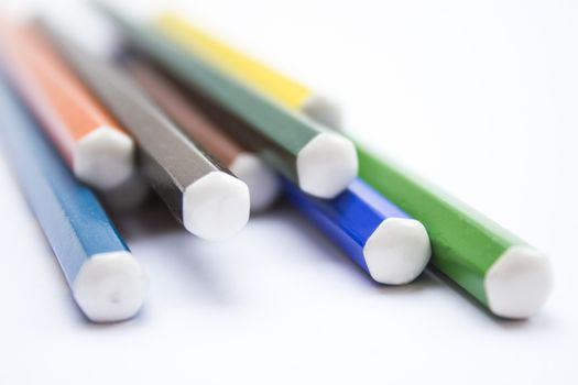 Different color pencils arranged on a white background.