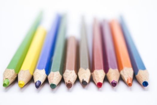 Different color pencils arranged on a white background.