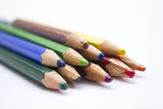 Different color pencils arranged on a white background.