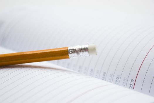 Pencil in a composition with a blank book with hardcovers.