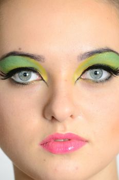 Very close photo of model face showing eyes and lips with colorful makeup, young teenager model from Poland.