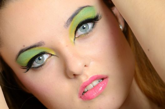 Close face portrait of young female. Polish teenager with colorful makeup.