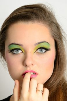 Young female model with colorful makeup. Face closeup portrait photo of teenager. 