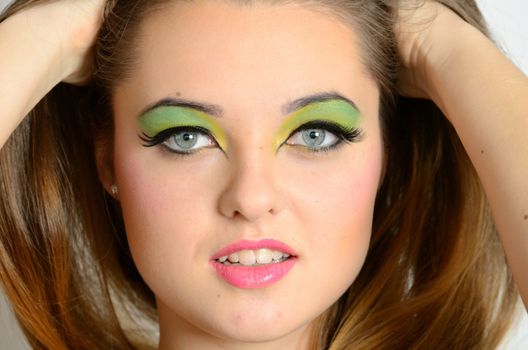 Close face portrait of young female. Polish teenager with colorful makeup.