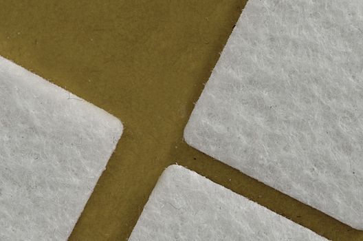 three white squares on a beige background 