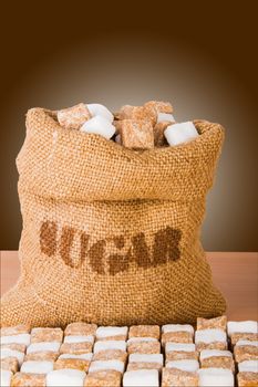 Brown and white sugar cubes, on a wooden background