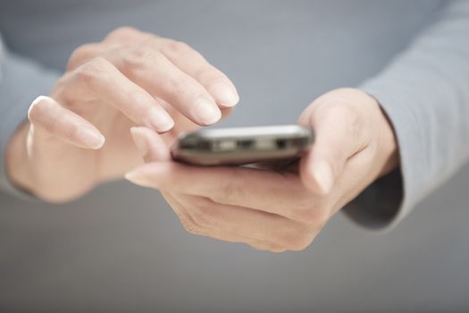 Human hands sending SMS via cell phone