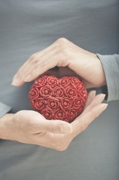 Hands of woman holding red heart. Close-up view