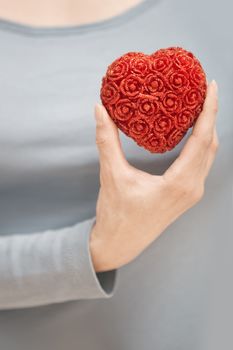 Woman hand holding heart as a symbol of love
