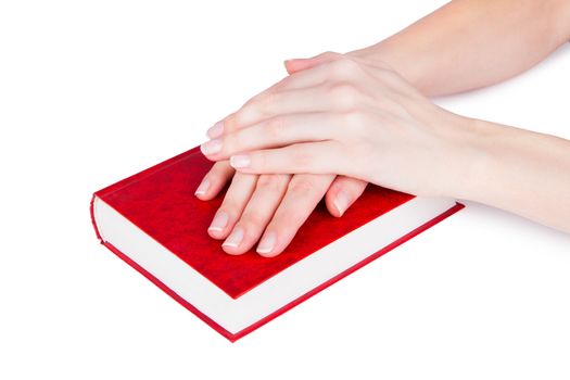 Women's hands on a closed book, isolated on white background.