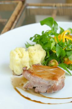close up Roasted duck breast  served with mashed potatoes and orange , fresh salad and white wine sauce