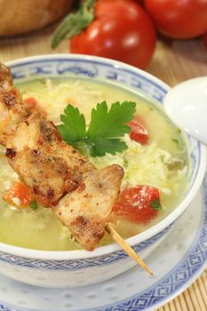 Asian Chicken soup with eggs, noodles, greens and tomatoes