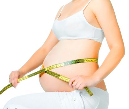 young pregnant woman measuring belly on a white background