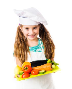 little girl with a board of vegetables and fruits on white background