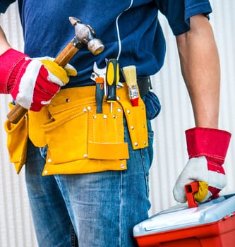 worker with tools and instrumentsa in leathern belt with box