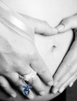 Pregnant woman holding her belly making a heart shape