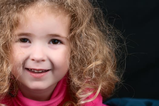 Little girl with curly hair wearing pink